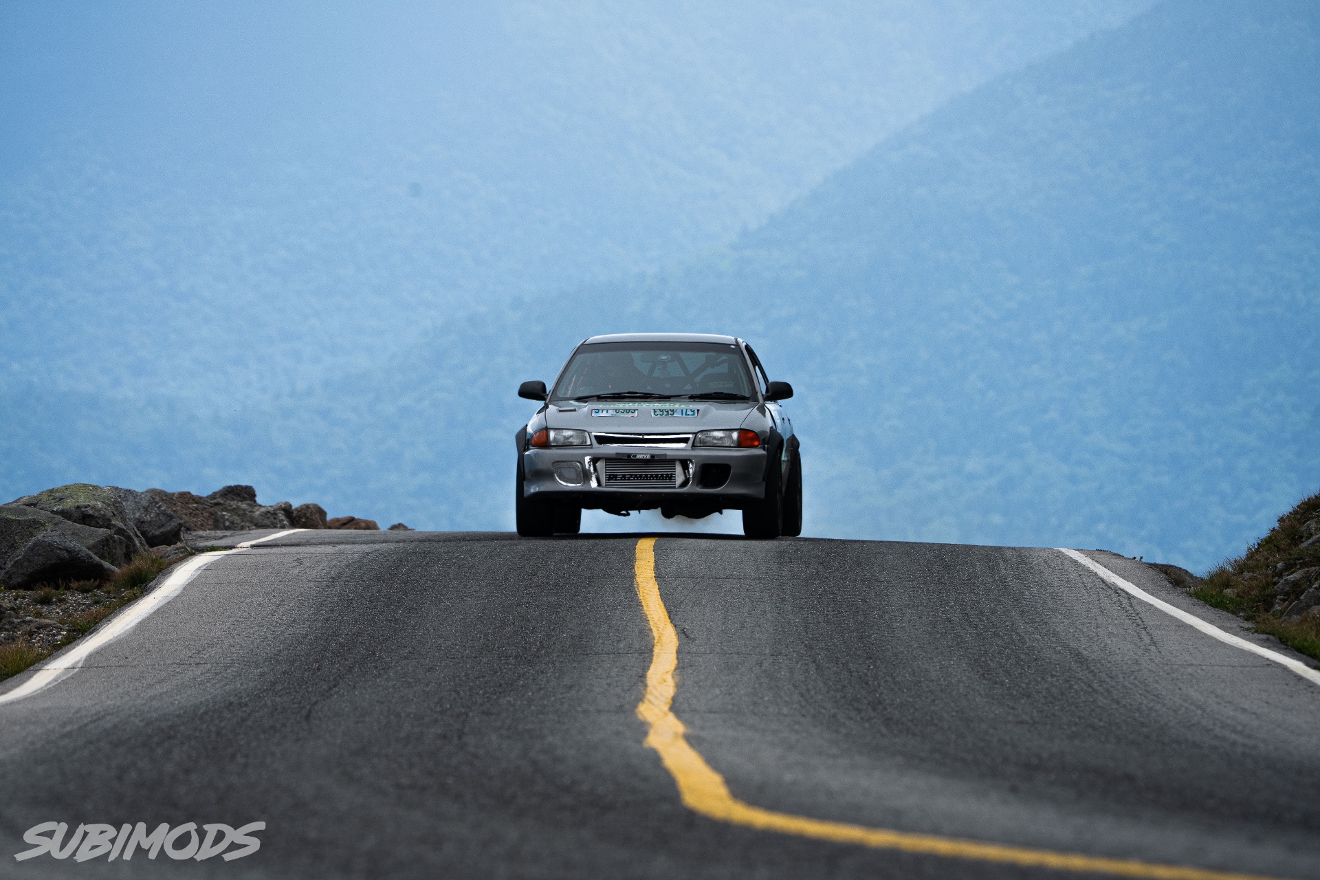The grey Evolution cresting a rise on the Mount Washington Auto Road