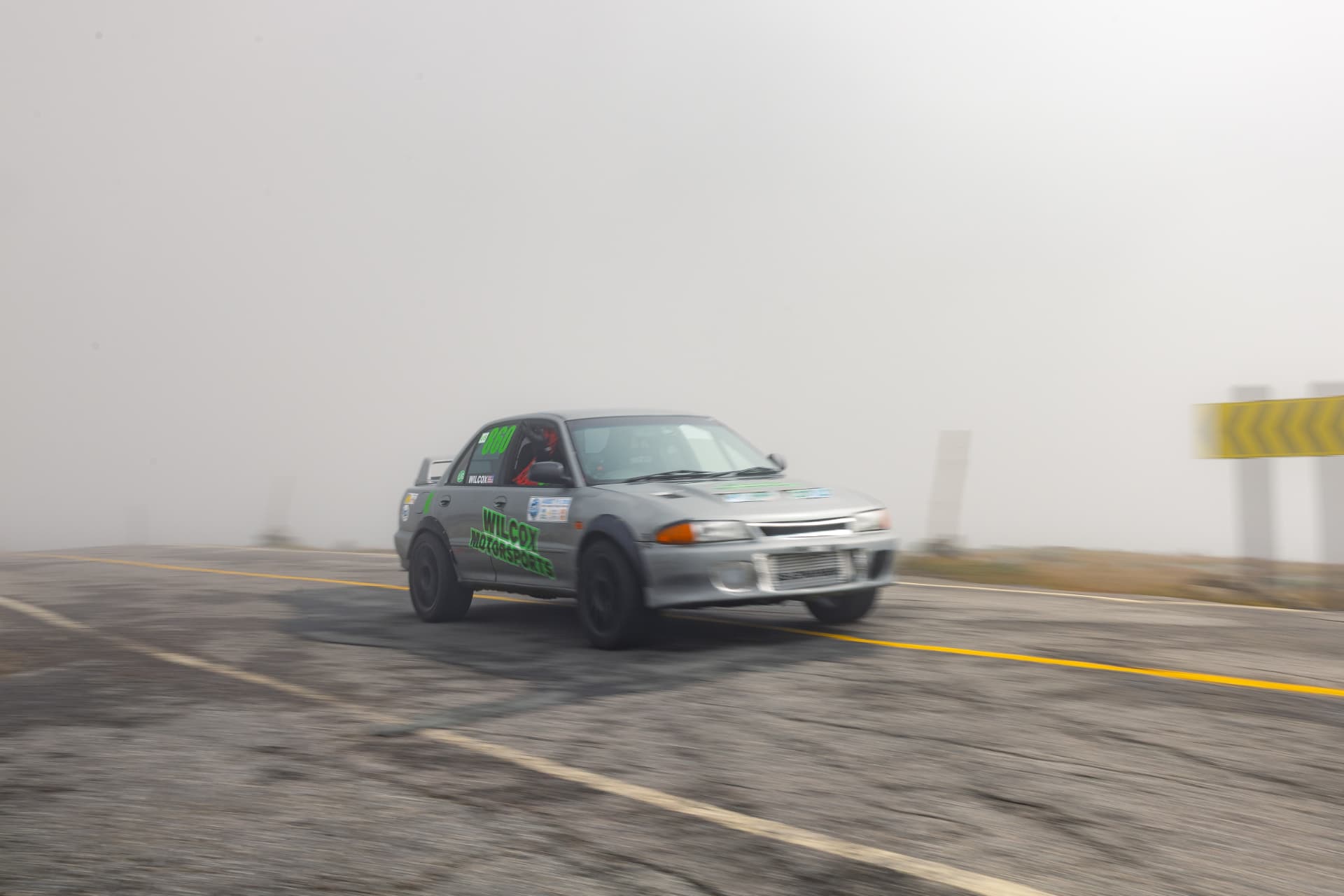 The grey Evolution powering along the fogged-in summit stretch of the Auto Road